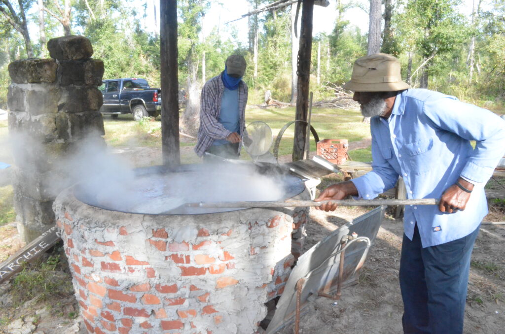 Community members making sugar cane syrup